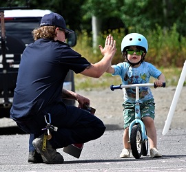 Emergency Worker High-Fives child on bike