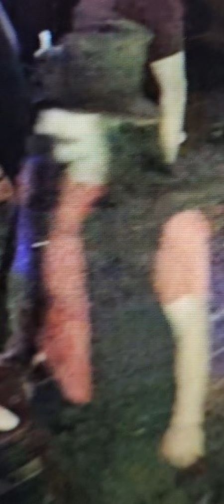 Image floue d&rsquo;un homme portant un chapeau, un chandail orange et une veste noire. 