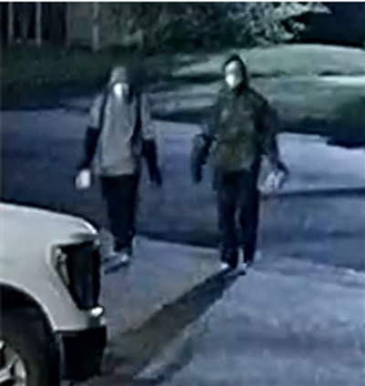 Two suspects walking toward camera with hoods up and masked faces