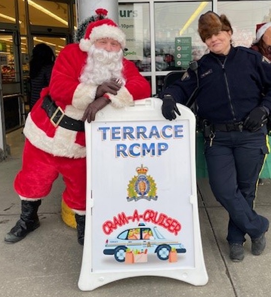 Santa and Cst Komlos standing by Terrace Cram a Cruiser sign