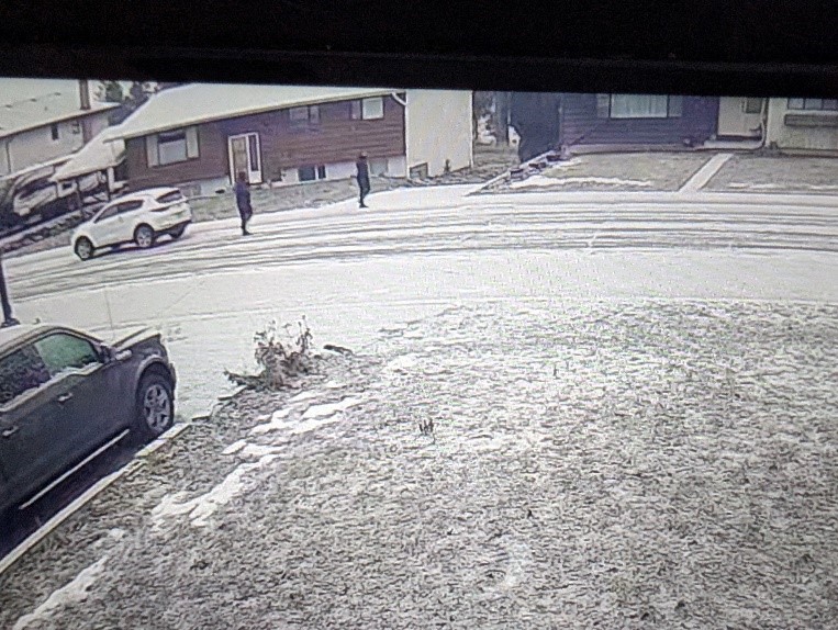 Two suspects wearing all black walking away from a white 4 door sport utility vehicle, believed to be a kia sportage, parked on Irvine Avenue in Merritt.