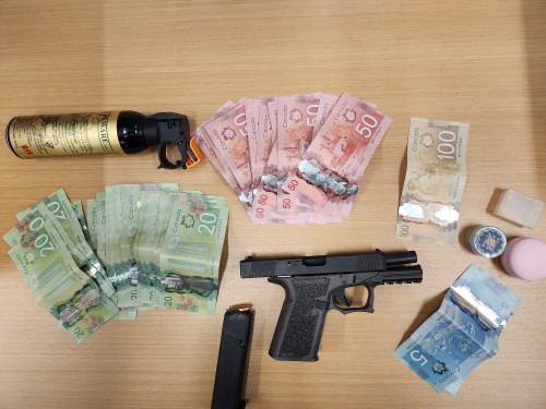 A pistol, cash, and drugs seized by BC Highway Patrol