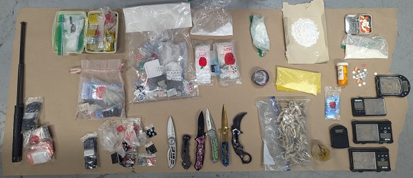 Display of drugs, pills, assorted knives, and drug paraphernalia