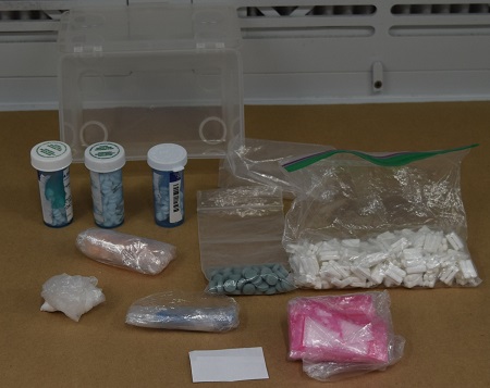 Various illicit drugs in three small medicine bottles and several plastic baggies.