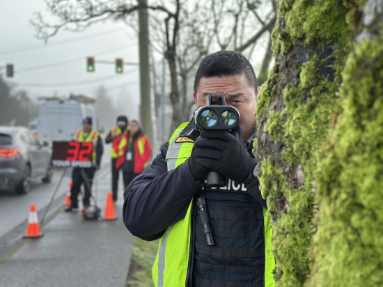 Richmond RCMP officer conducting speed enforcement, behind a tree