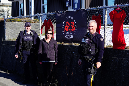 Photo of Sgt. Erin Stevenson, Alert Bay RCMP Detachment Commander; Anne Jackson, Detachment Service Assistant; and Cst. Bruce Verhaeghe, putting up a display outside of Alert Bay Detachment to showcase their support of the 5th annual healing gathering.
