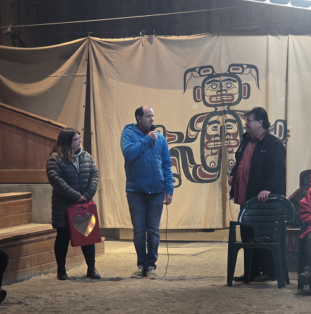 Photo of IPS police officer Cst. Seanan Sharp speaking into the microphone to Chief Victor Isaac to showcase his appreciation.