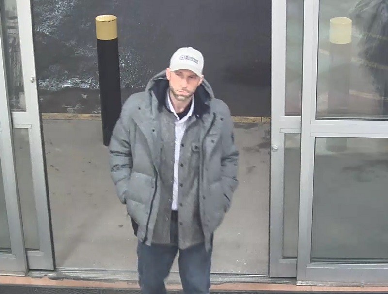 Caucasian male, 30-40 years old, wearing jeans, grey winter jacket, beige or white baseball hat.