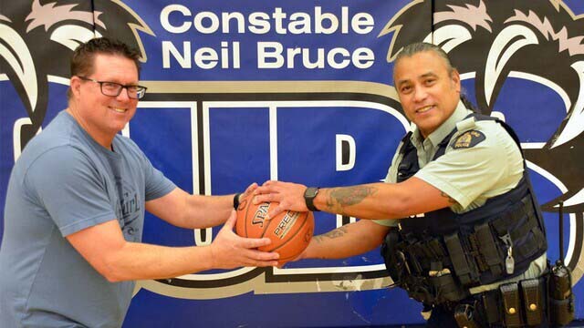 Cst. Rolly Williams and Brad Vissia holding a basketball