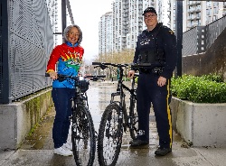 Coquitlam RCMP&rsquo;s Cops for Cancer riders; Corporal Neil Roemer and retired Mountie Tess Landry holding bicycles while standing side by side.
