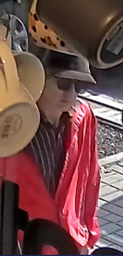seconf photo of male wearing red coat, hat and sunglasses