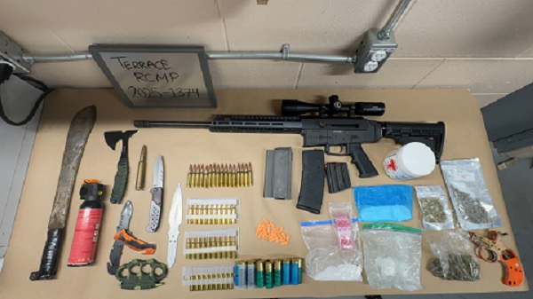 Display on table of weapons, rifle, knives, bear spray, suspected drugs, ammunition