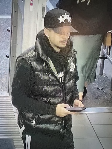 Fraud Suspect wearing all black holding a phone