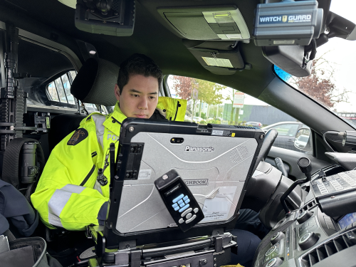 Richmond RCMP officer inside a police vehicle using a computer