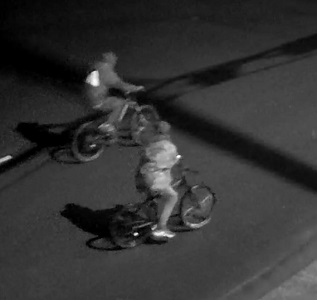 Side view of two unknown individuals on bikes