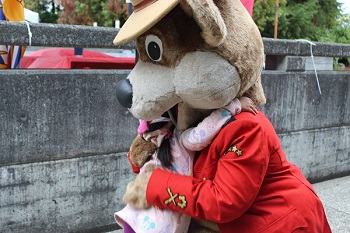 L&rsquo;Ours prudent est agenouill&eacute; pour serrer dans ses bras une petite fille portant une robe rose. 