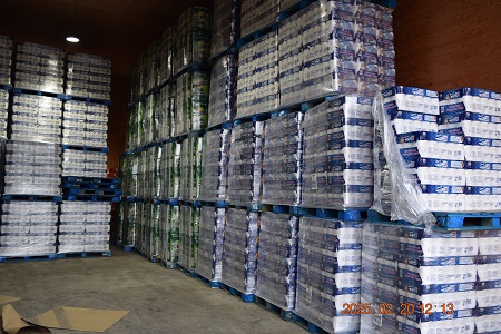 Skids of paper towel and toilet paper stacked in a warehouse.