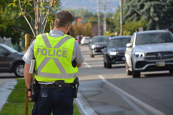 Photo of our RCMP officer looking at traffic holding a radar gun