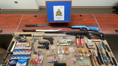 Display on table of weapons, drugs, tobacco, cash