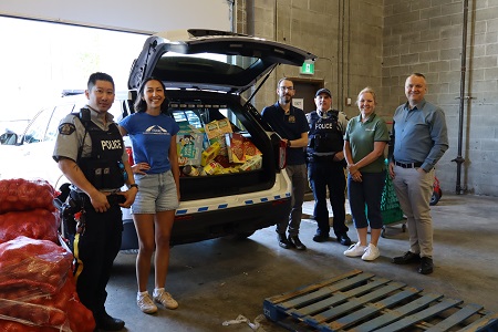 Group photo of Coquitlam RCMP officers and staff dropping off items to the SHARE Society