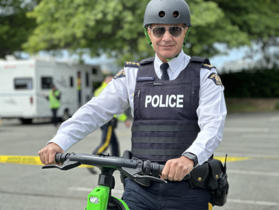 Chief Superintendent Dave Chauhan riding an e-scooter