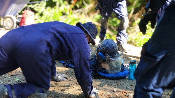 Photo of safety equipment placed on an individual while being removed from a locking device in the ground