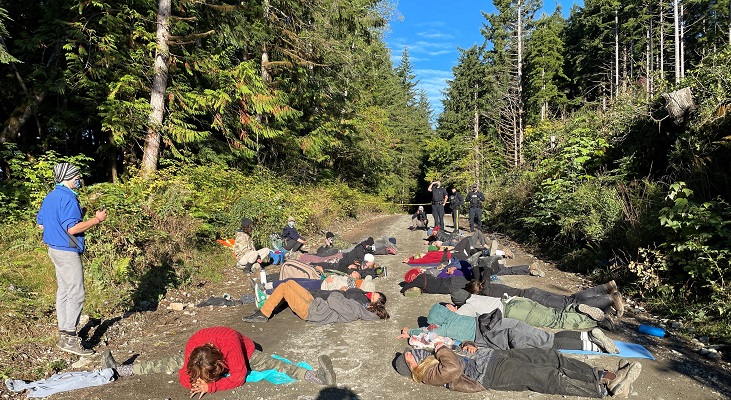 Photo de personnes couch&eacute;es sur le sol au milieu du chemin forestier