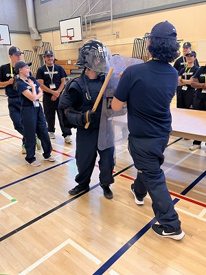 Candidates in Tactical gear practicing crowd control