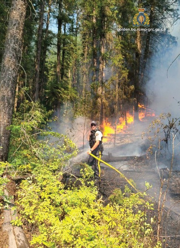 (Le gendarme Mark Tataryn en train de lutter contre un feu de for&ecirc;t au coin de la route transcanadienne et de Forde Station Road, &agrave; l&rsquo;ouest de Golden, en Colombie-Britannique)