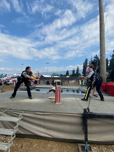RCMP officers Cst. Valotaire and Cst. Taylor during a sawing competition.