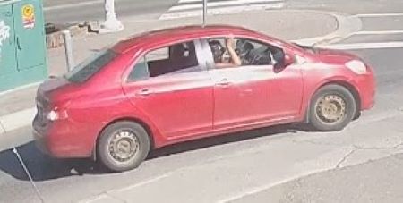 Une berline rouge &agrave; quatre portes sans enjoliveurs.