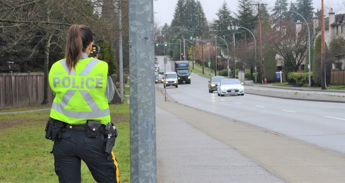 Officer conducting speed enforcement standing along side a roadway