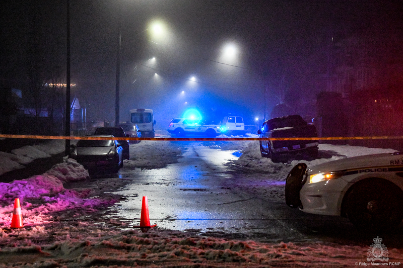 Two police cars on 123 Avenue in Maple Ridge during the evening. In between the police cars is yellow police tape indicating not to cross.