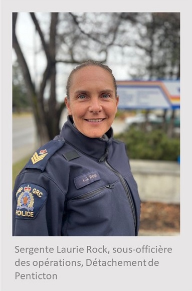 Femme blanche debout pr&egrave;s d&rsquo;une enseigne de la GRC et regardant par-dessus son &eacute;paule droite. Elle porte un blouson bleu de la GRC. Sous la photo, on peut lire : Sergente Laurie Rock, sous-offici&egrave;re des op&eacute;rations, D&eacute;tachement de Penticton.