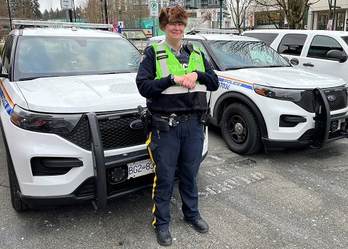 La gendarme Jen Barker à côté d’un véhicule de police identifié.