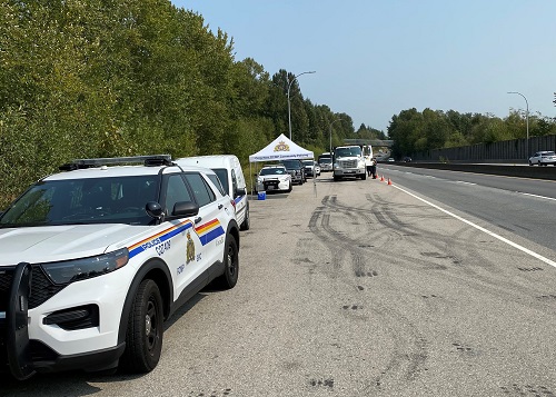 Véhicule identifié de la GRC devant un contrôle routier du CVSE.